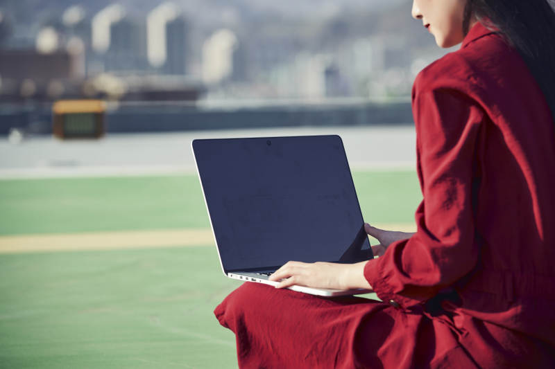 亚洲商务年轻女性在楼顶停机坪使用电脑办公图片