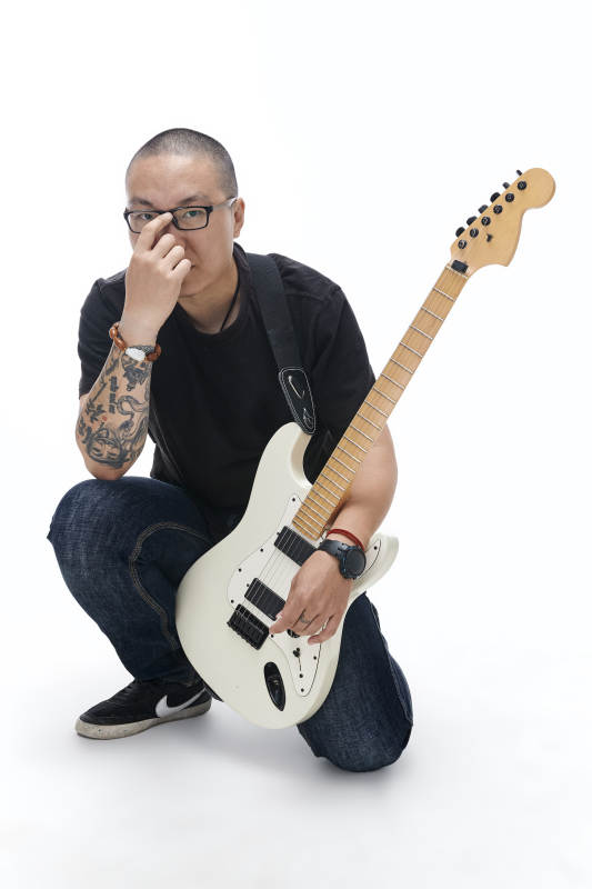 手持电吉他展示演奏的亚洲男性摇滚乐手人像图片