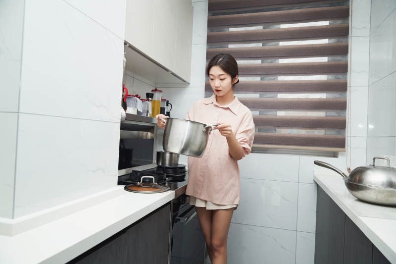 在厨房下厨的年轻亚洲女性图片