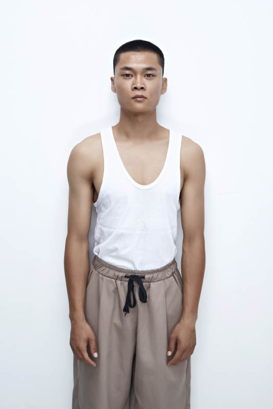 白色背景下展示健身预备拉伸动作的亚洲男性图片