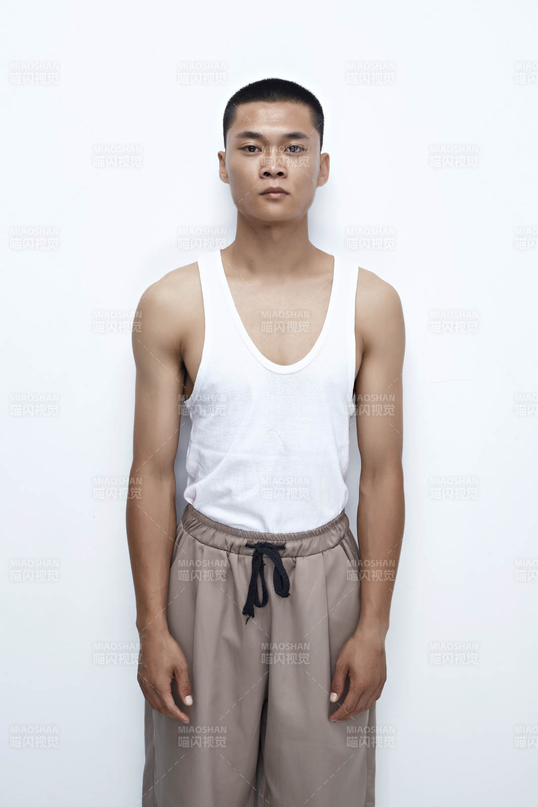 白色背景下展示健身预备拉伸动作的亚洲男性图片