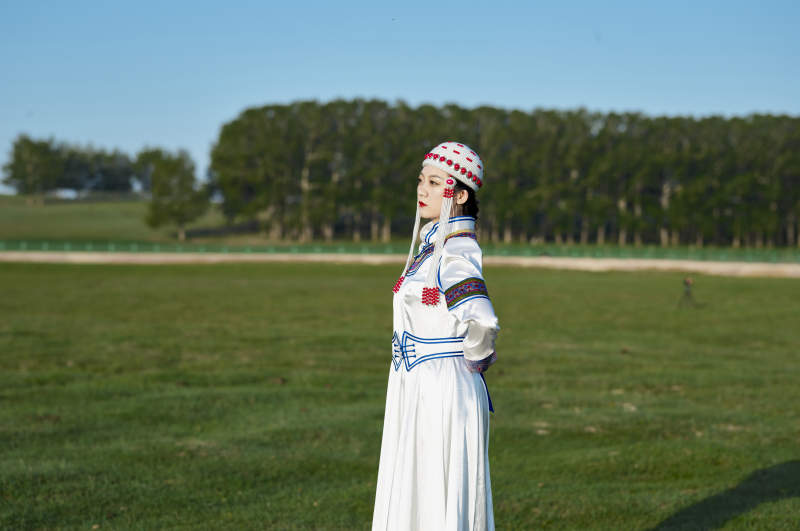 草原上穿着蒙古族传统服饰的亚洲年轻美少女图片