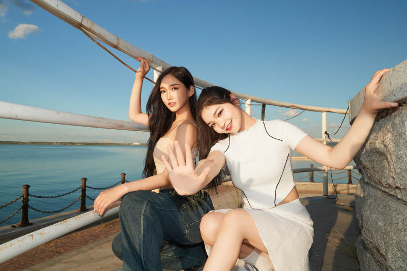 盛夏在景区湖边灯塔上拍照游玩的美女们图片