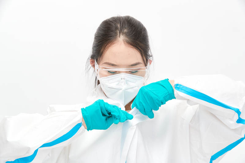穿白色防护服佩戴护目镜口罩的女性医疗人员图片