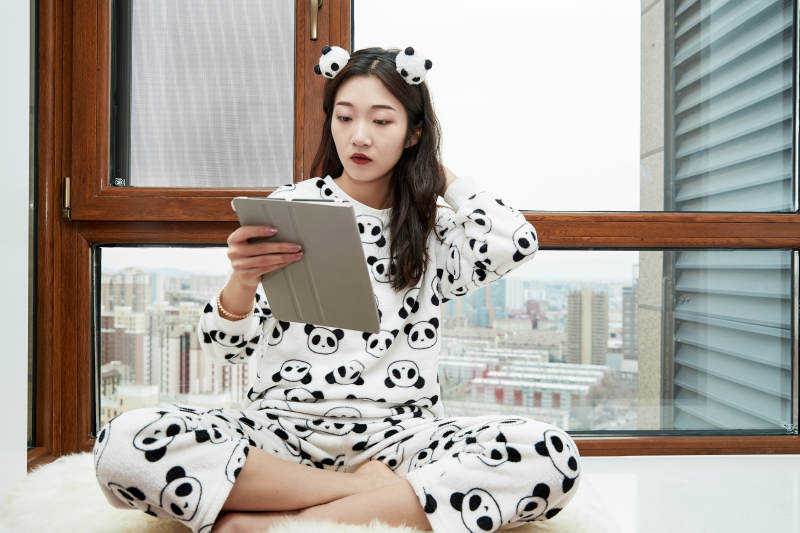 躺在舒适的飘窗上听音乐追剧的亚洲少女图片