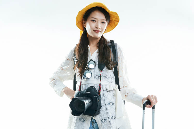 白色背景下准备出发旅行的美丽东方女大学生图片