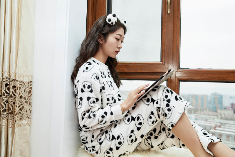 躺在舒适的飘窗上听音乐追剧的亚洲少女图片