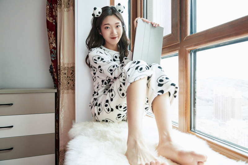 躺在舒适的飘窗上听音乐追剧的亚洲少女图片