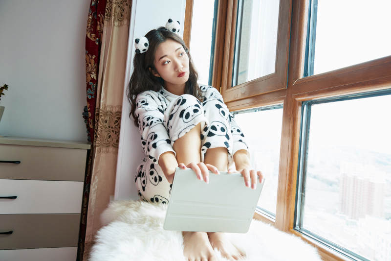 躺在舒适的飘窗上听音乐追剧的亚洲少女图片