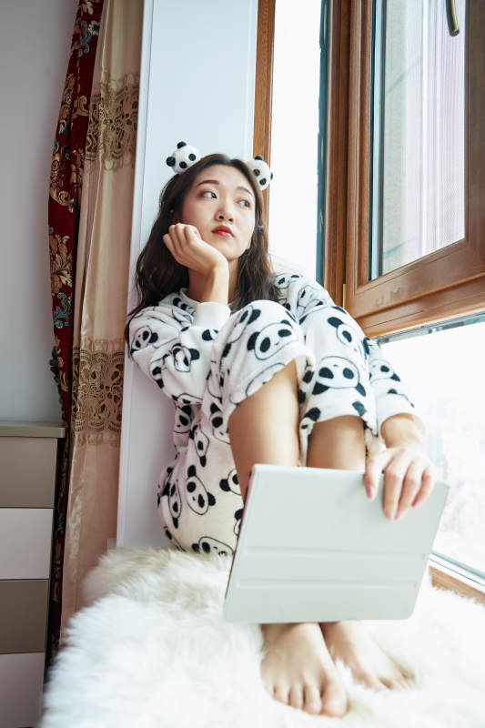 躺在舒适的飘窗上听音乐追剧的亚洲少女图片