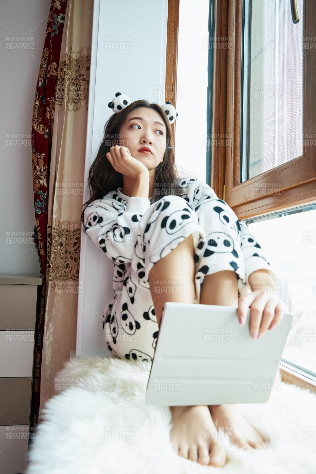 躺在舒适的飘窗上听音乐追剧的亚洲少女图片