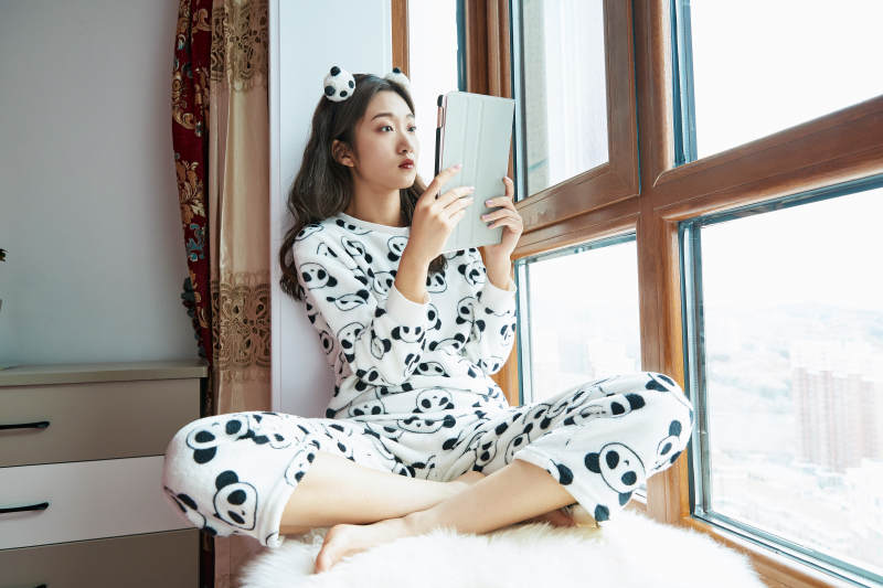 躺在舒适的飘窗上听音乐追剧的亚洲少女图片