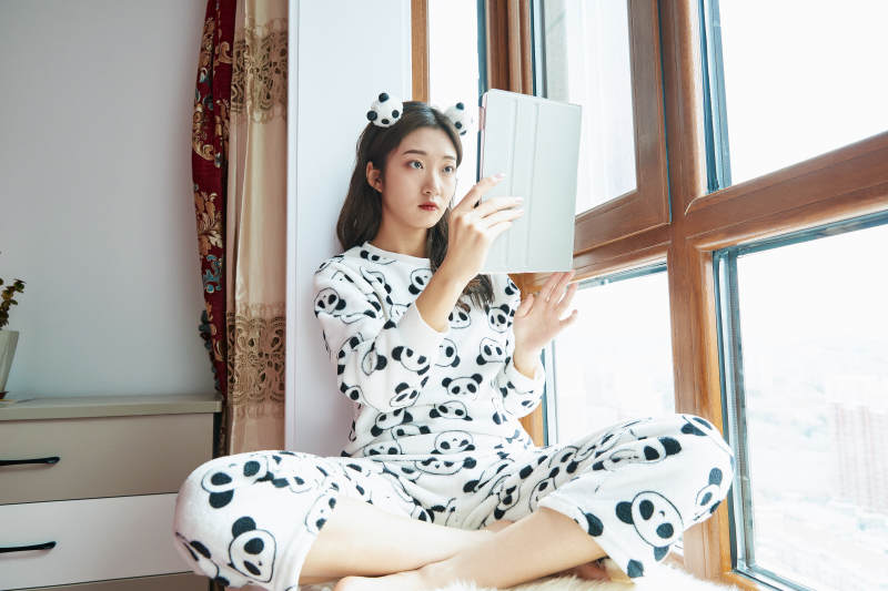 躺在舒适的飘窗上听音乐追剧的亚洲少女图片