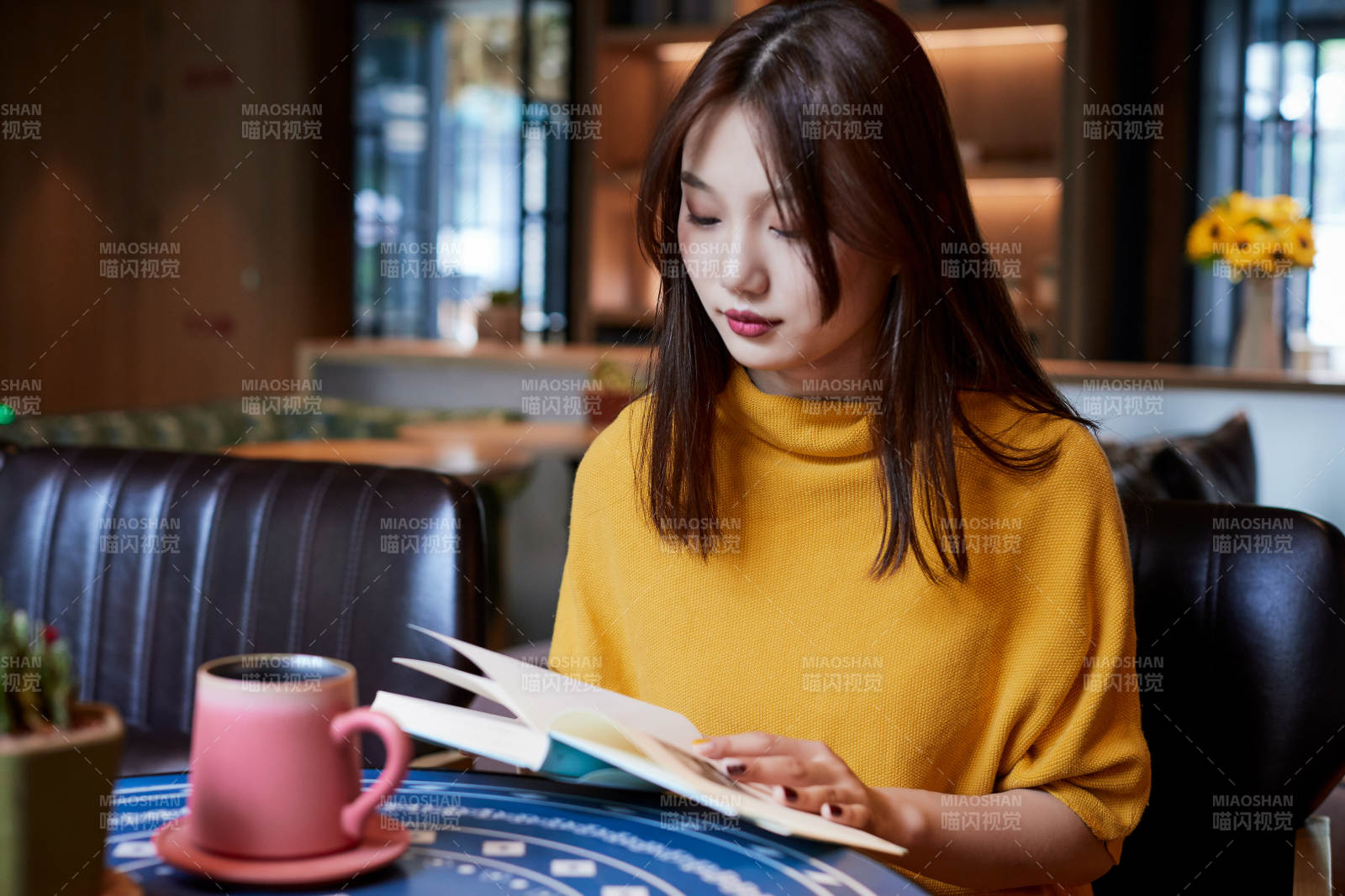 在图书咖啡馆阅读书籍的少女图片