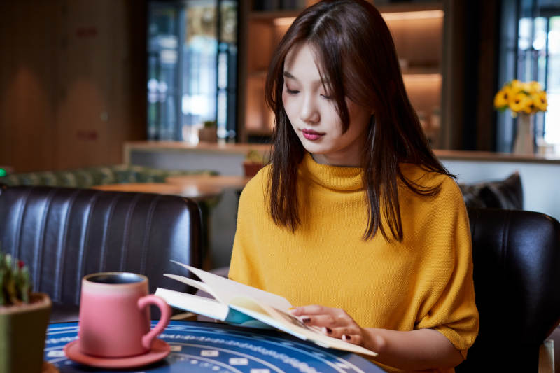 在图书咖啡馆阅读书籍的少女图片