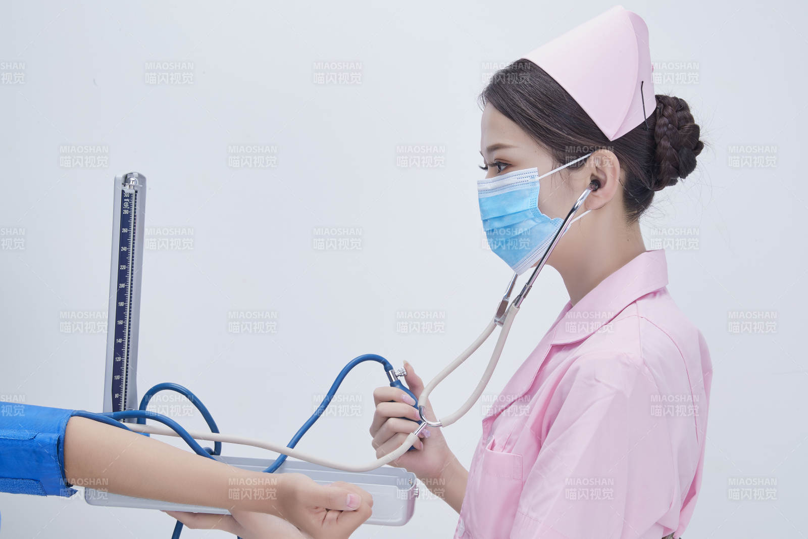 手拿血压测量仪为患者诊治量血压的女性护士图片