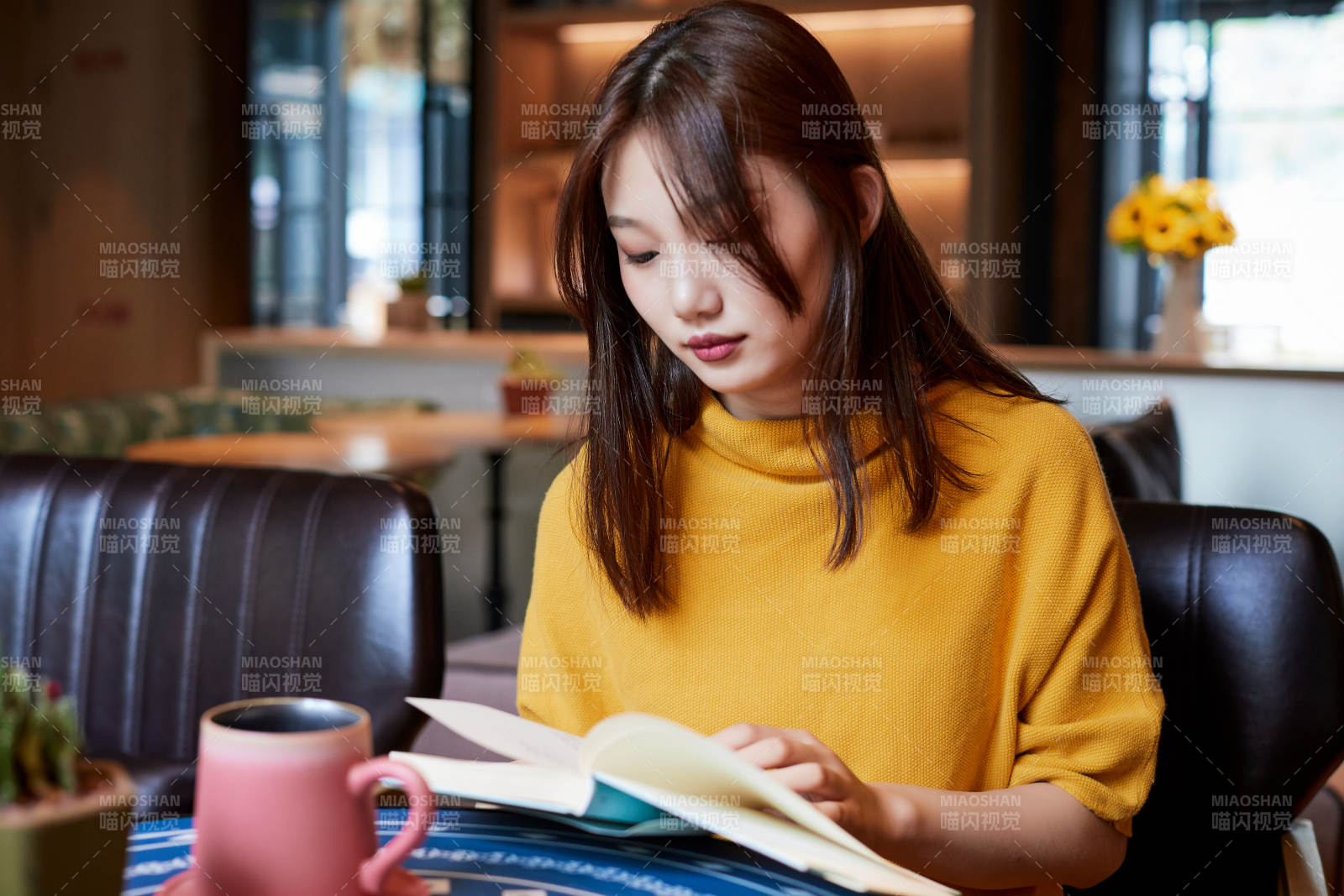 在图书咖啡馆阅读书籍的少女图片