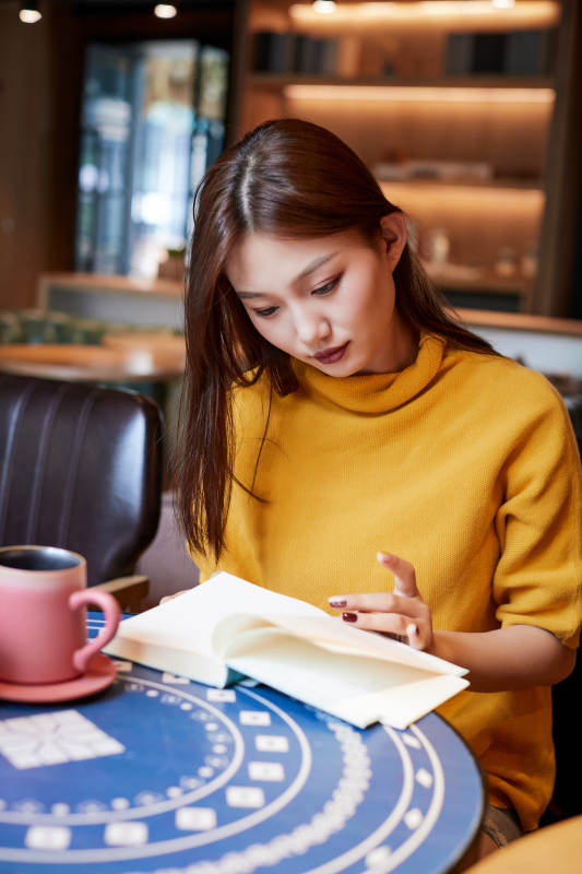 在图书咖啡馆阅读书籍的少女图片