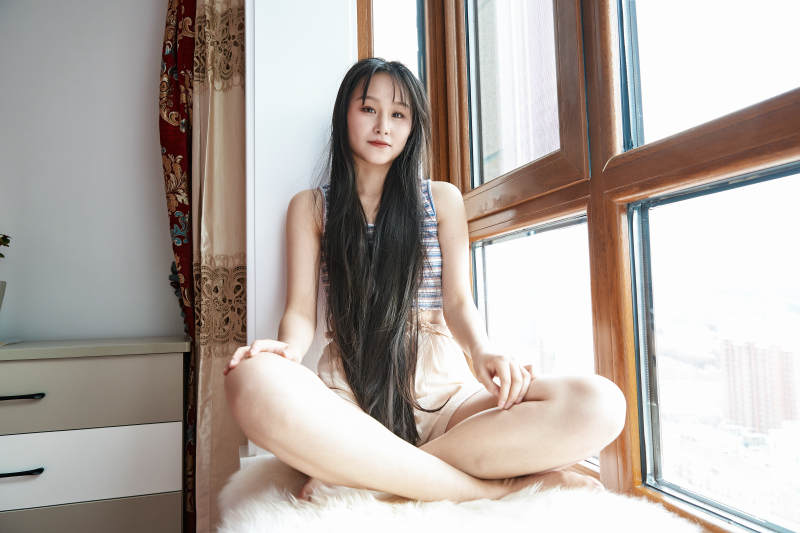 躺在舒适的飘窗上听音乐追剧的亚洲少女图片