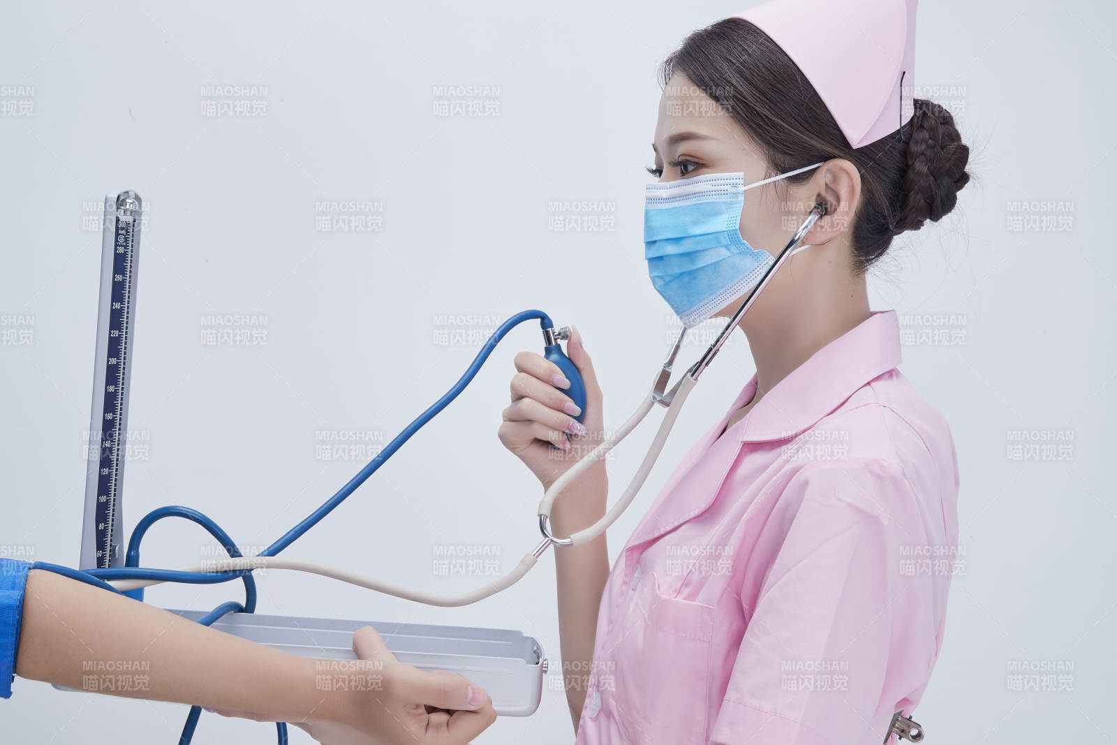 手拿血压测量仪为患者诊治量血压的女性护士图片