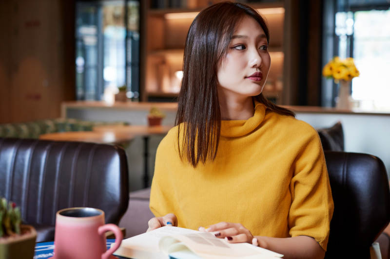 在图书咖啡馆阅读书籍的少女图片