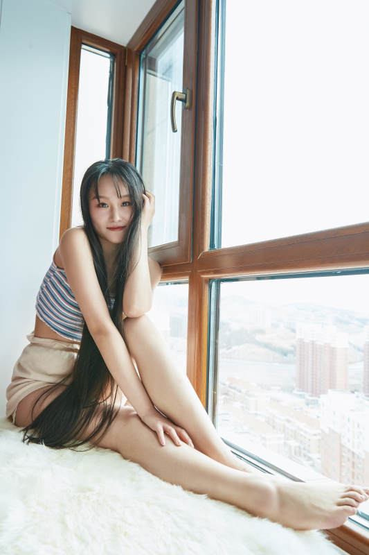 躺在舒适的飘窗上听音乐追剧的亚洲少女图片