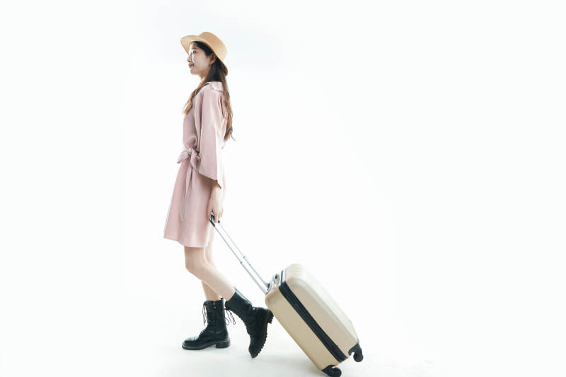 白色背景下准备出发旅行的美丽东方女大学生图片