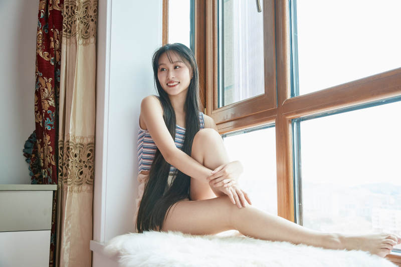 躺在舒适的飘窗上听音乐追剧的亚洲少女图片