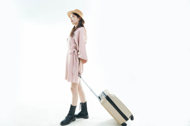 白色背景下准备出发旅行的美丽东方女大学生图片