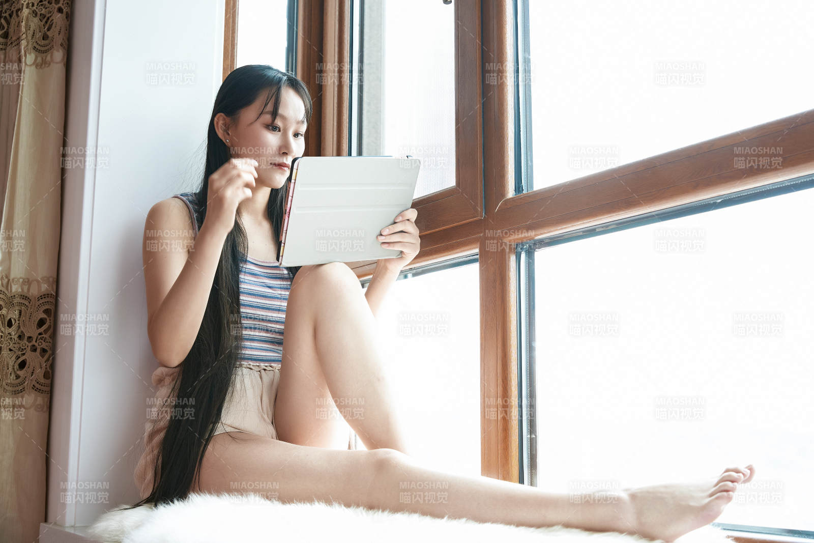 躺在舒适的飘窗上听音乐追剧的亚洲少女图片