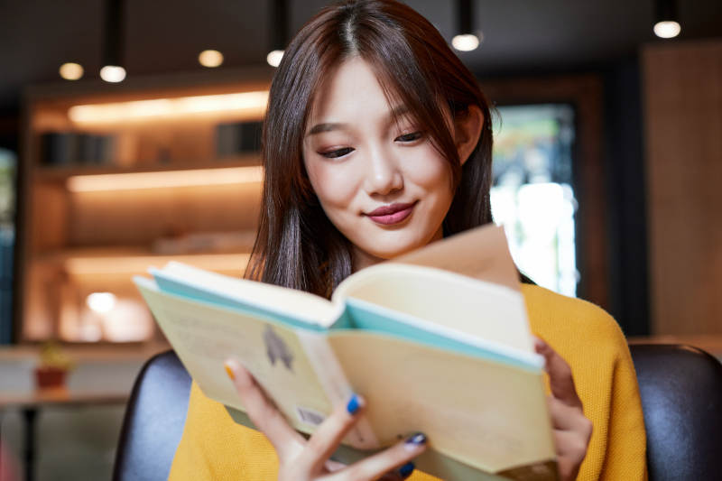 在图书咖啡馆阅读书籍的少女图片