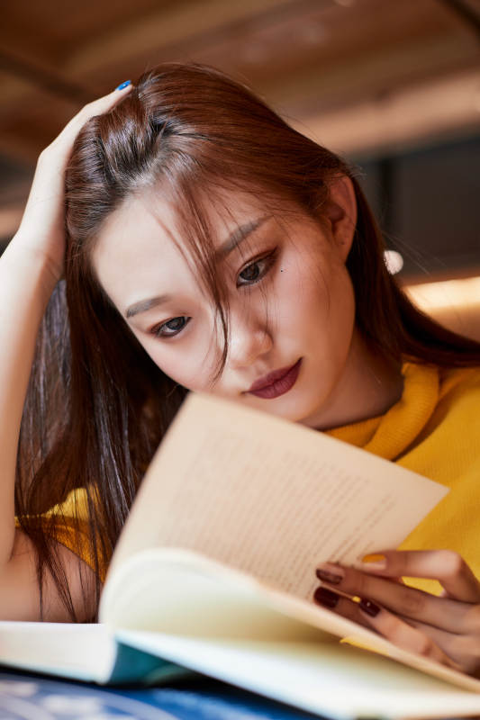 在图书咖啡馆阅读书籍的少女图片