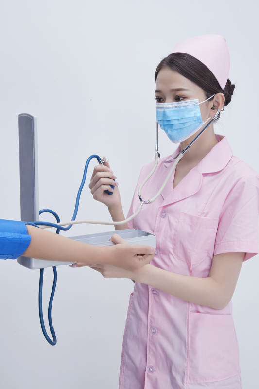手拿血压测量仪为患者诊治量血压的女性护士图片