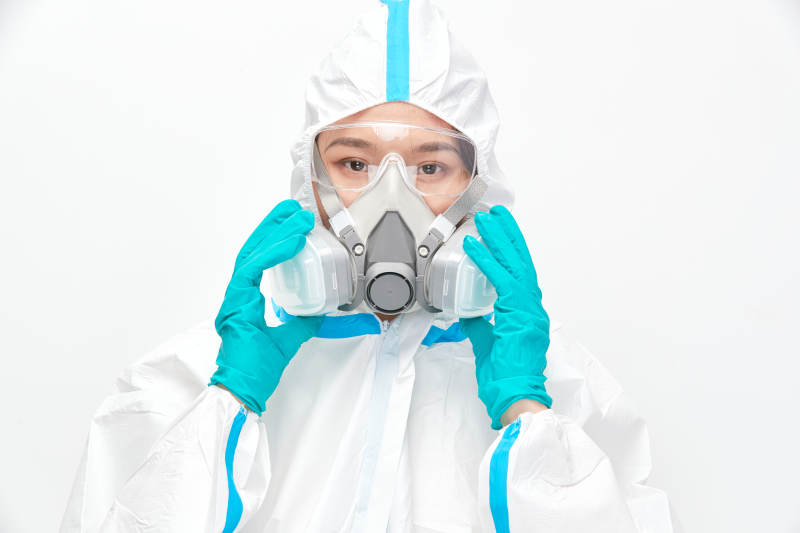 穿白色防护服佩戴护目镜口罩的女性医疗人员图片