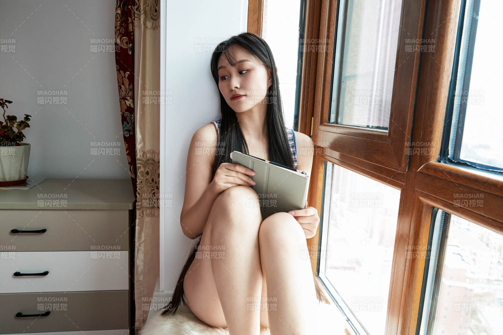 躺在舒适的飘窗上听音乐追剧的亚洲少女图片