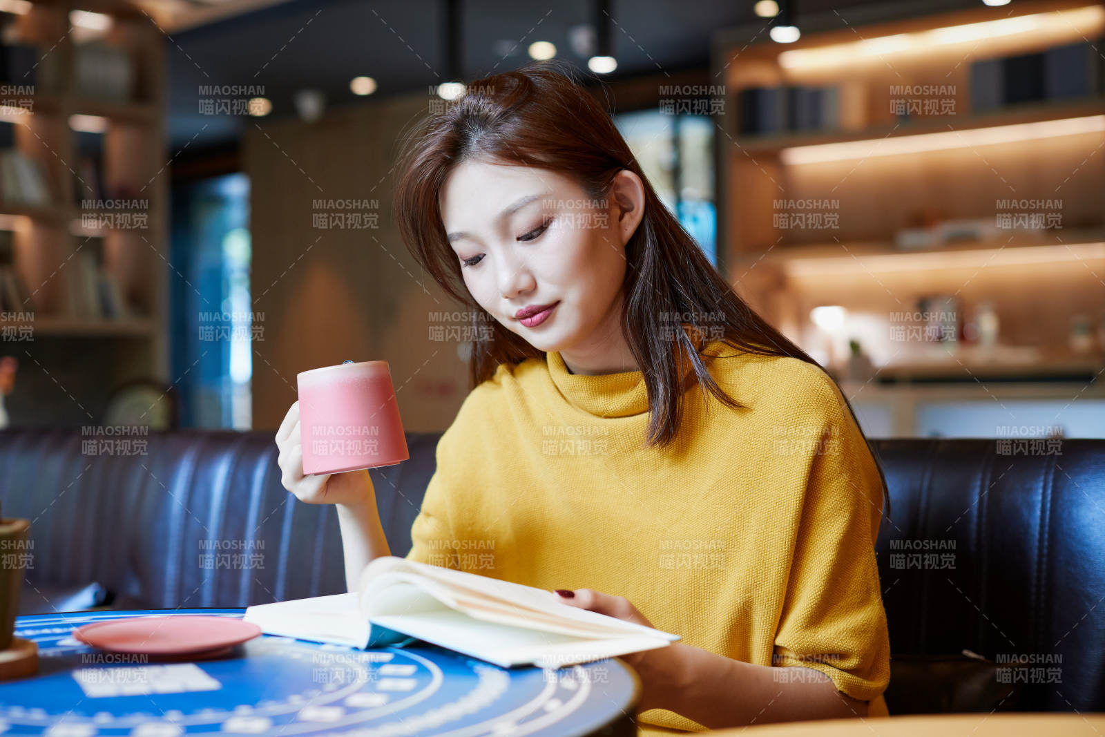 在图书咖啡馆阅读书籍的少女图片