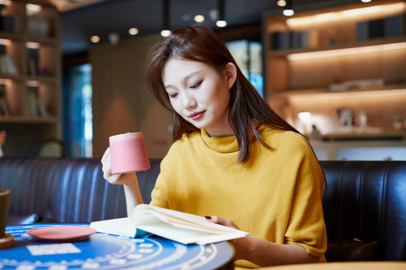 在图书咖啡馆阅读书籍的少女图片