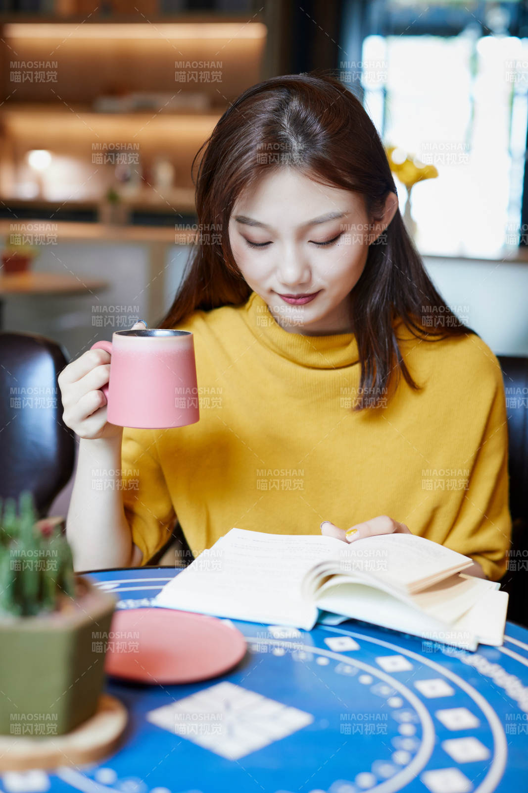 在图书咖啡馆阅读书籍的少女图片
