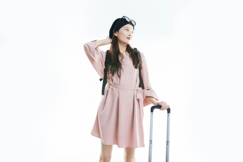 白色背景下准备出发旅行的美丽东方女大学生图片
