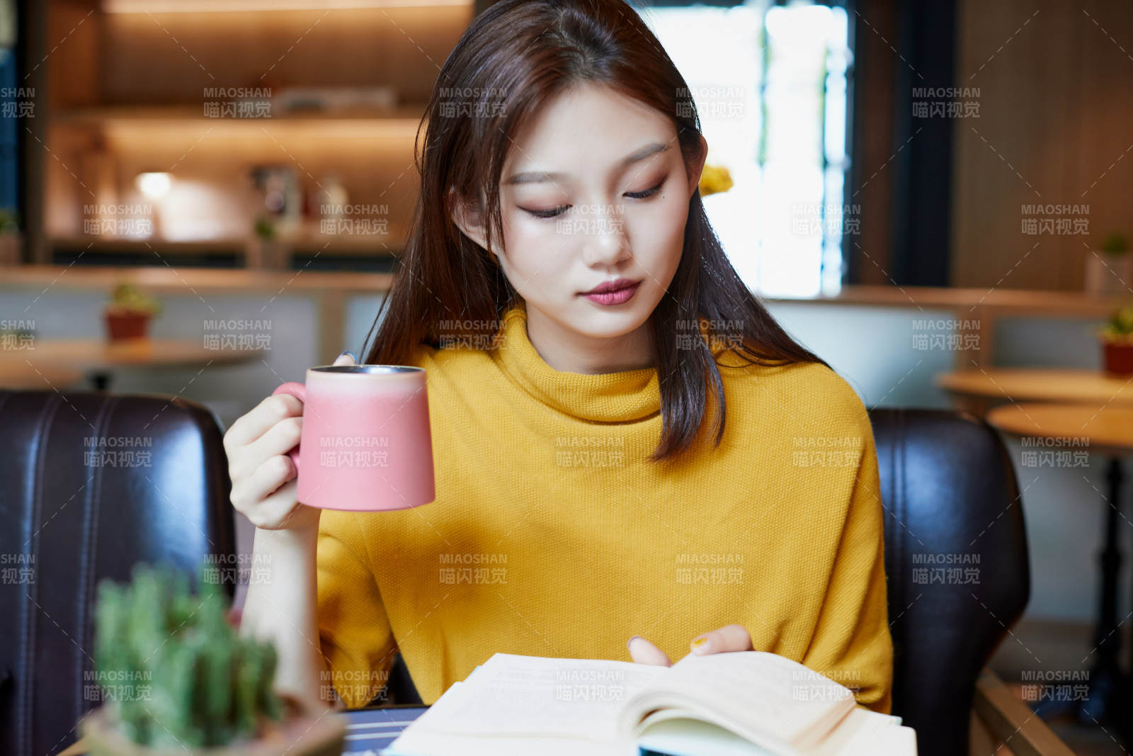 在图书咖啡馆阅读书籍的少女图片