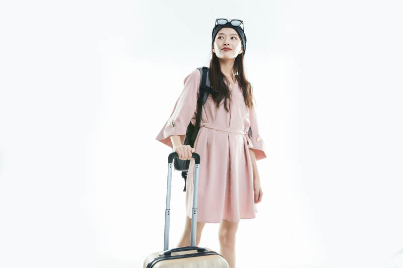 白色背景下准备出发旅行的美丽东方女大学生图片
