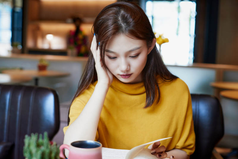 在图书咖啡馆阅读书籍的少女图片