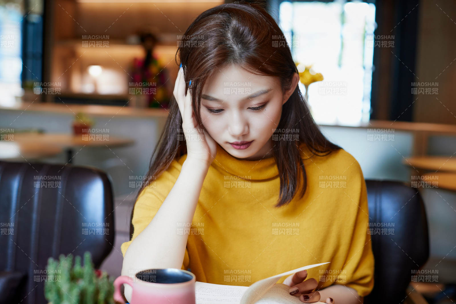 在图书咖啡馆阅读书籍的少女图片