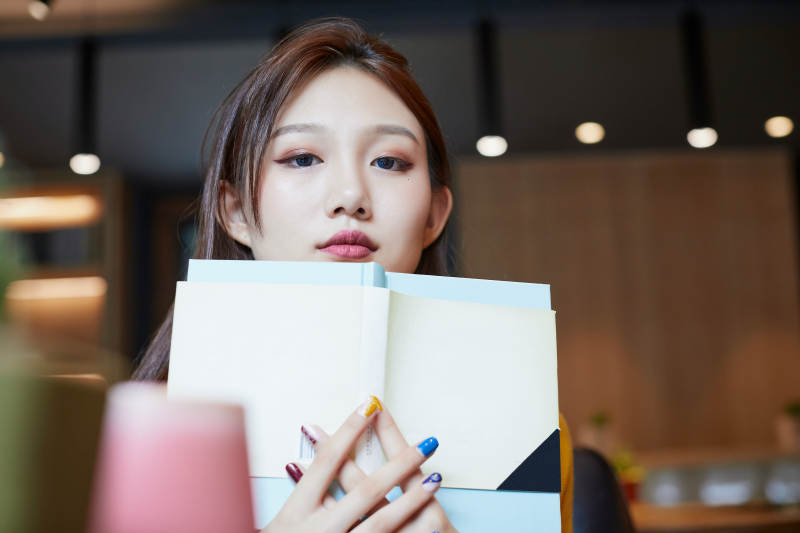 在图书咖啡馆阅读书籍的少女图片