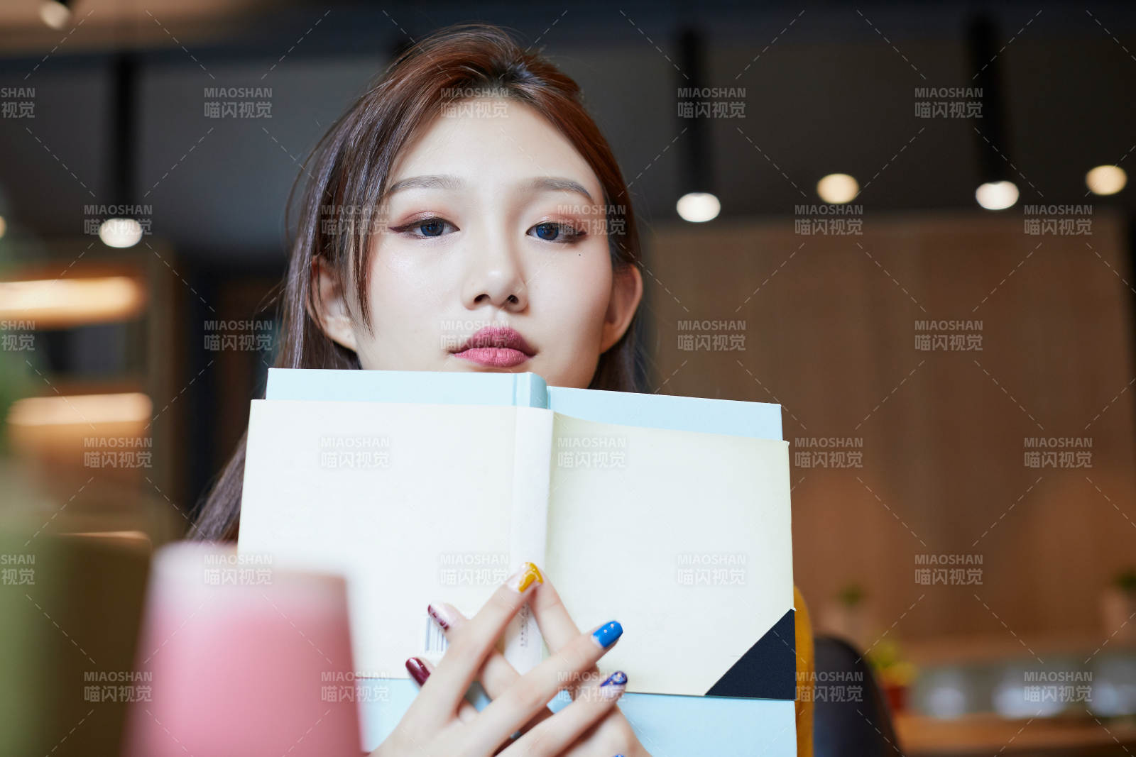 在图书咖啡馆阅读书籍的少女图片