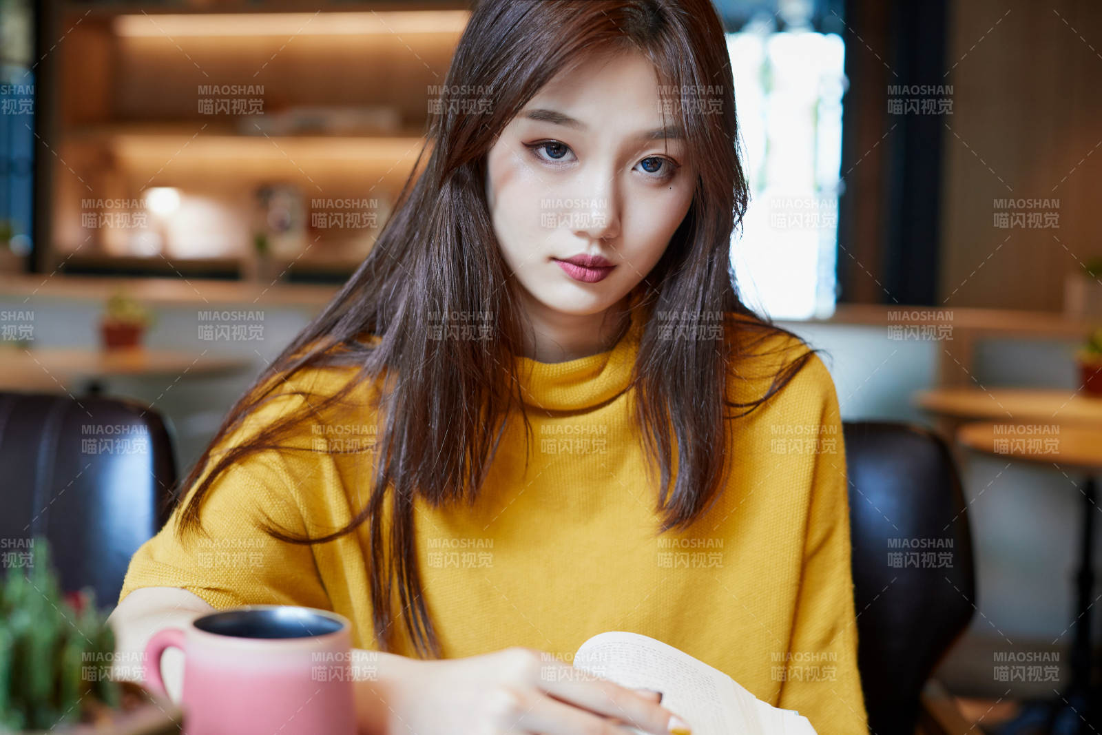 在图书咖啡馆阅读书籍的少女图片