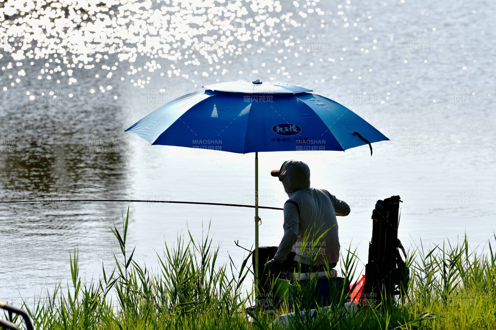湖畔垂钓 伞下静谧图片