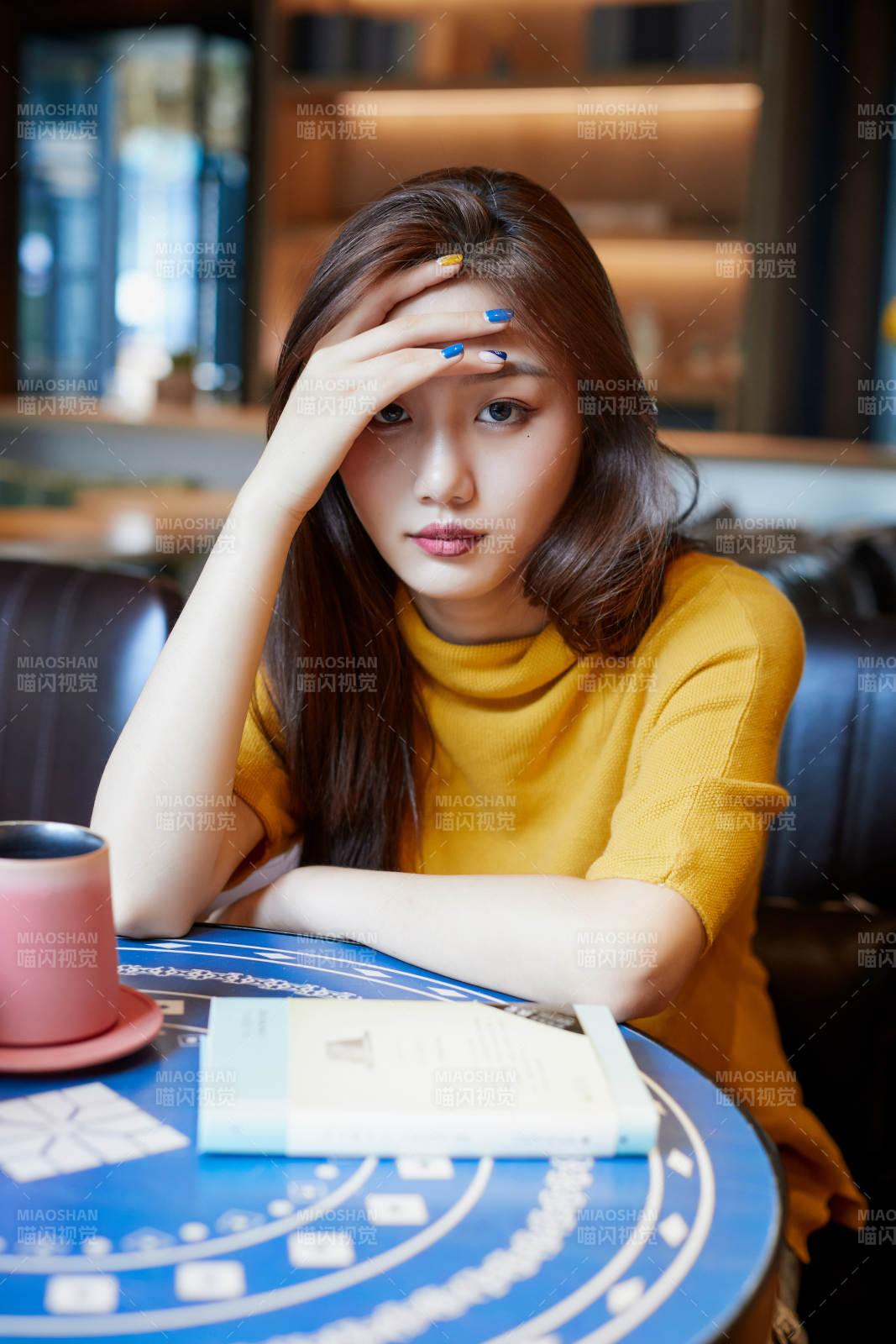 在图书咖啡馆阅读书籍的少女图片