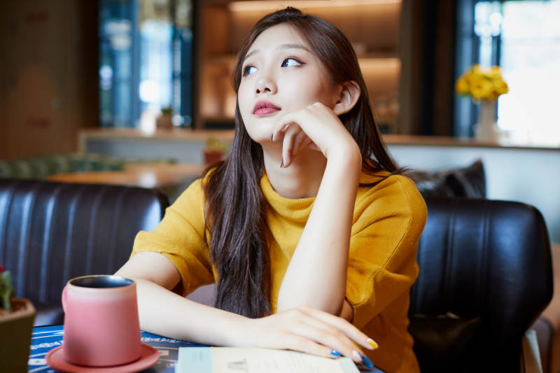 在图书咖啡馆阅读书籍的少女图片