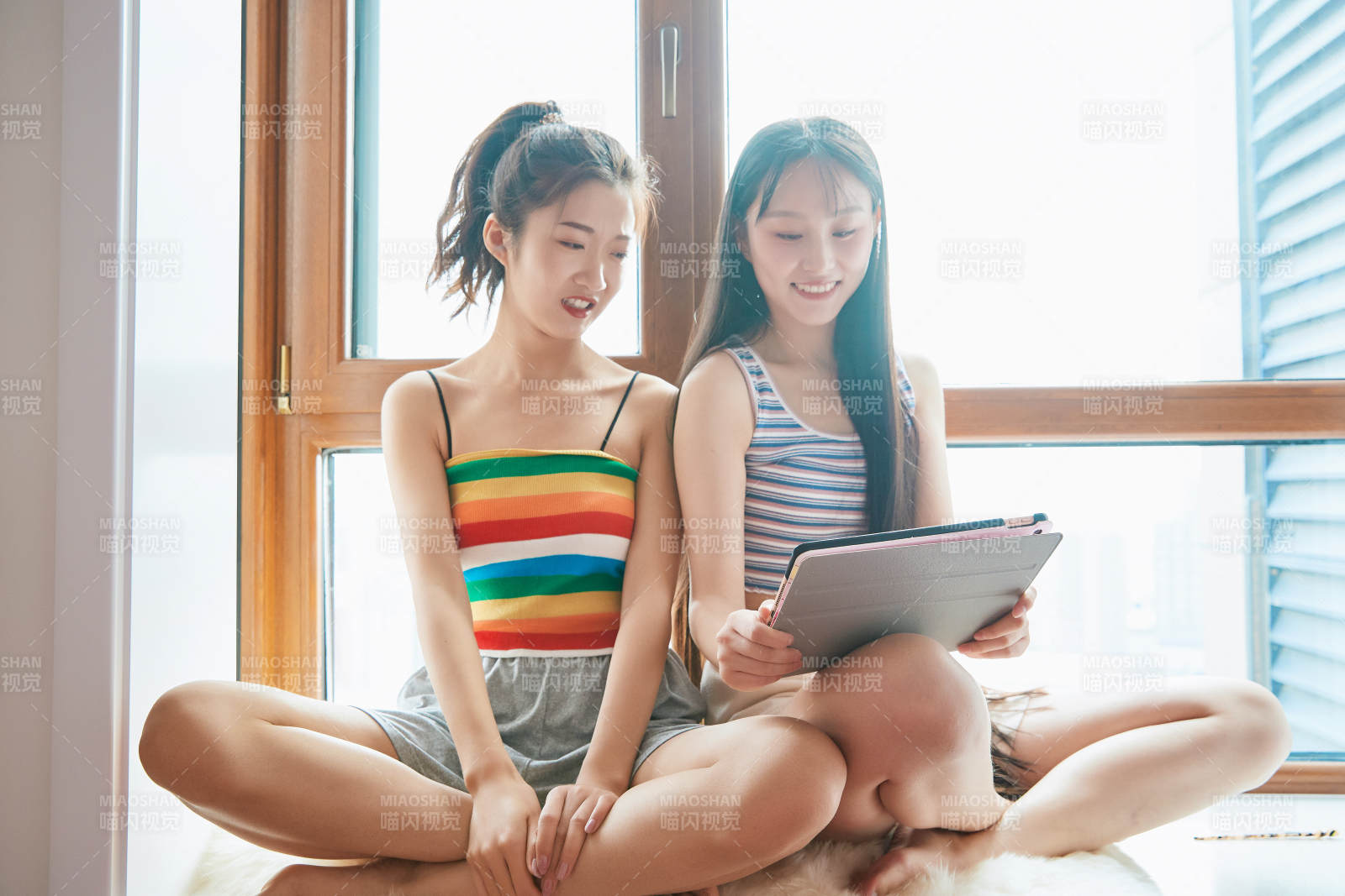 午后坐在飘窗上追剧休息的闺蜜少女图片